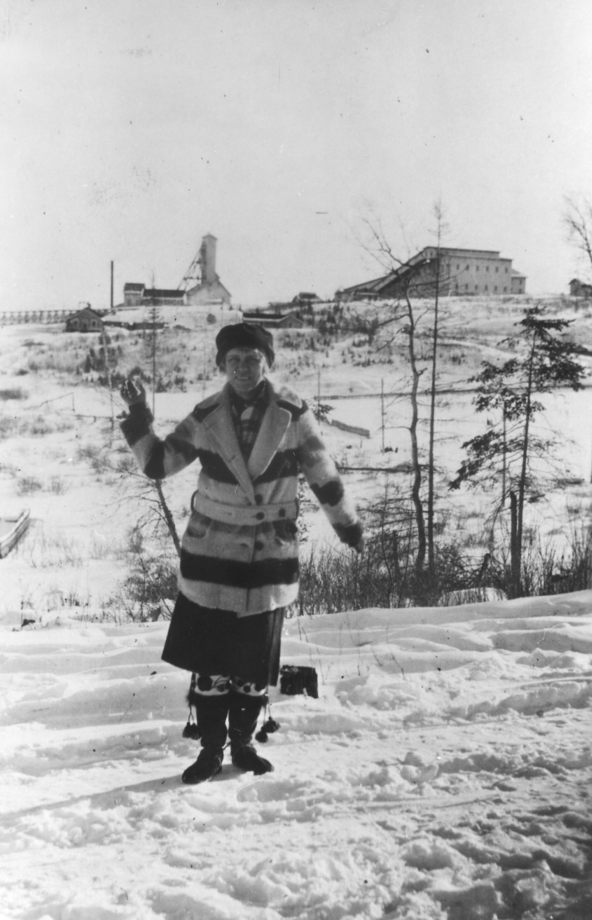 Margaret Cochenour wearing a HBC coat with Howey Mine in the background, 1928